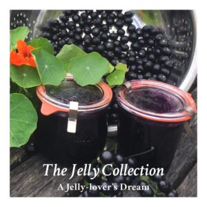 Two glass jars of huckleberry jelly in front of a strainer with huckleberries and some nasturtium leaves