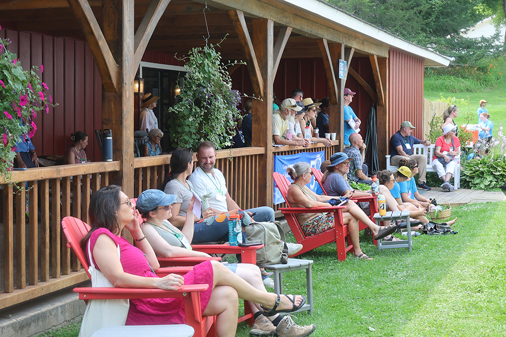 Crowd of people sitting outside of a building.