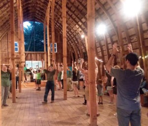 People gather in a barn for a barn dance.
