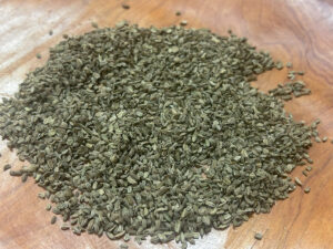 A wooden bowl full of a pile of carrot seeds