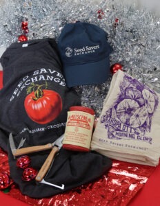 Holiday gifts including a shirt, hat, towel, and garden tools arranged in front of tinsel