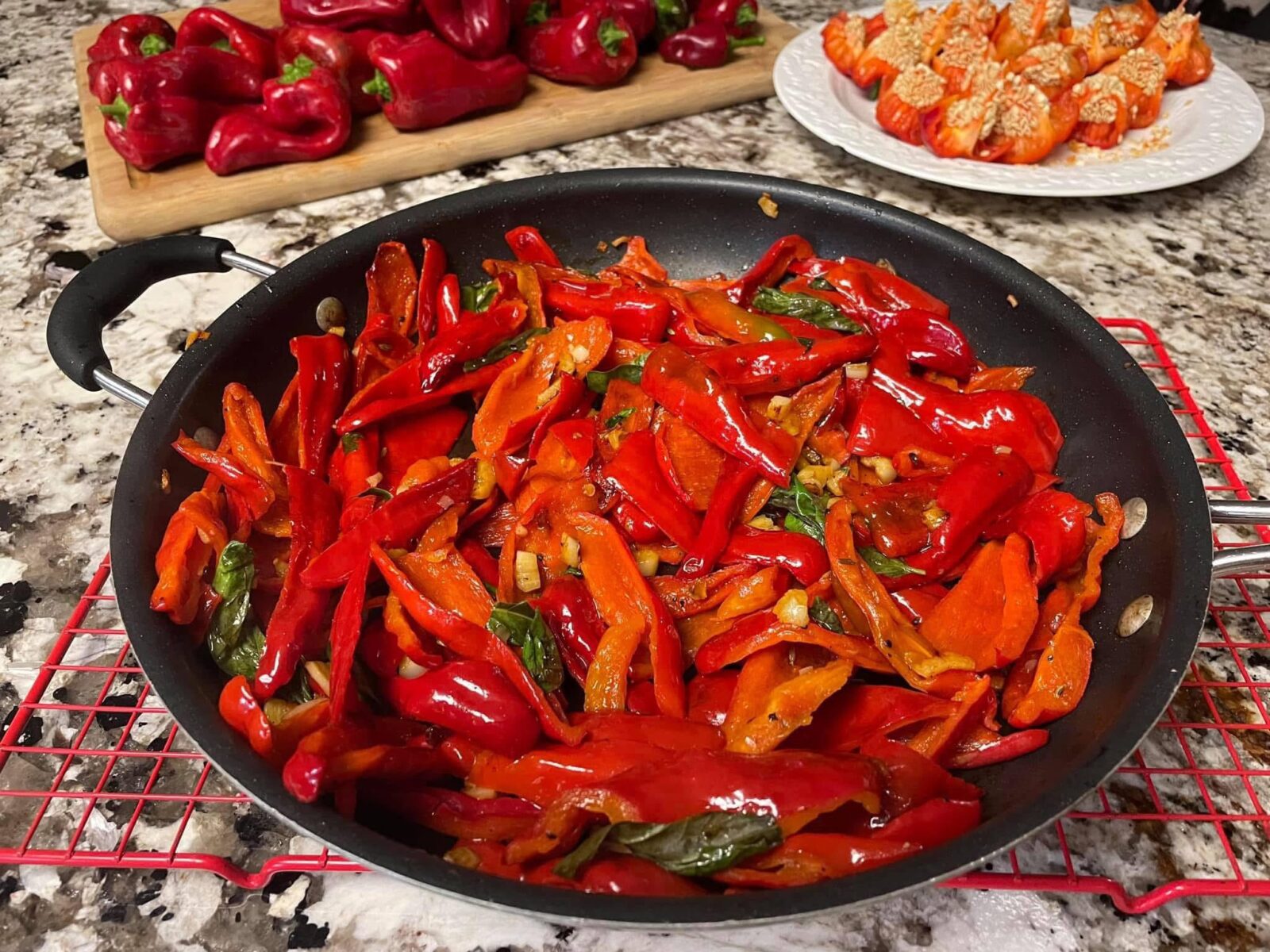 Many sliced red peppers, cooked in a skillet on a countertop.