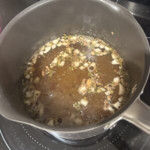 Boiling watermelon pickling brine in a metal pot on a stovetop