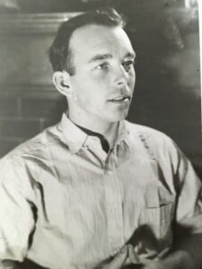 An old black and white photo of a young man looking to the right of the camera