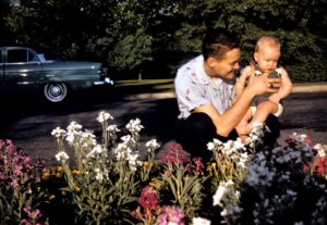 Young Craig Lehoullier surveys a flowerbed with his dad, Wilfred.