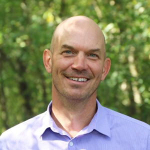 Man smiles to camera.