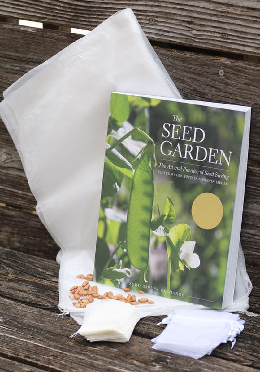 A book, large mesh bags, seed packets, and blossom bags on a wooden bench