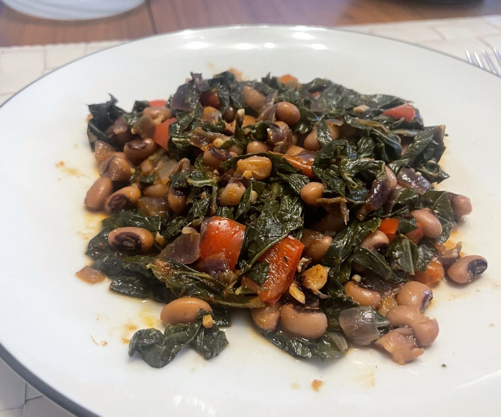 A plate with black-eyed peas and collard greens