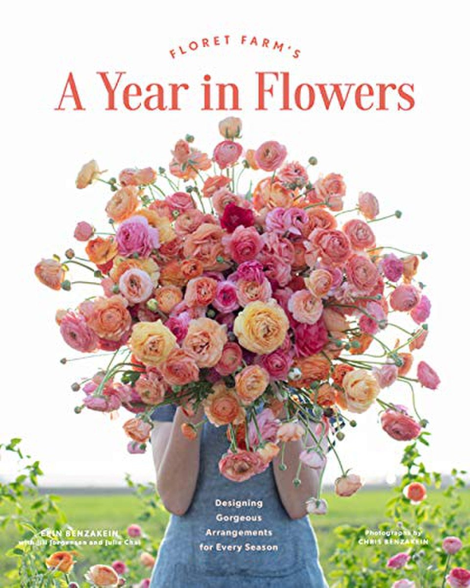 A person holds a large bouquet of pink and orange shaded flowers covering their face