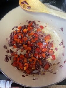 A pot of chopped onions, pepper, and garlic