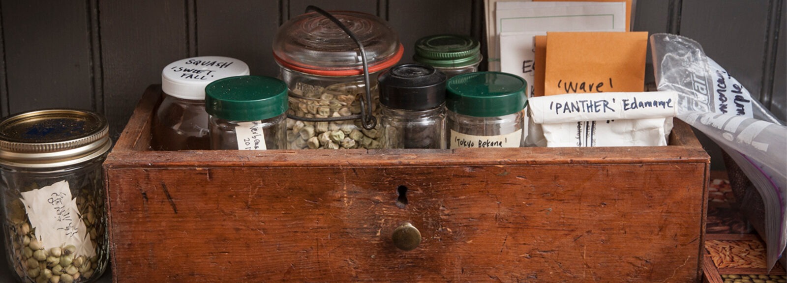 A wood box with jars and envelopes inside
