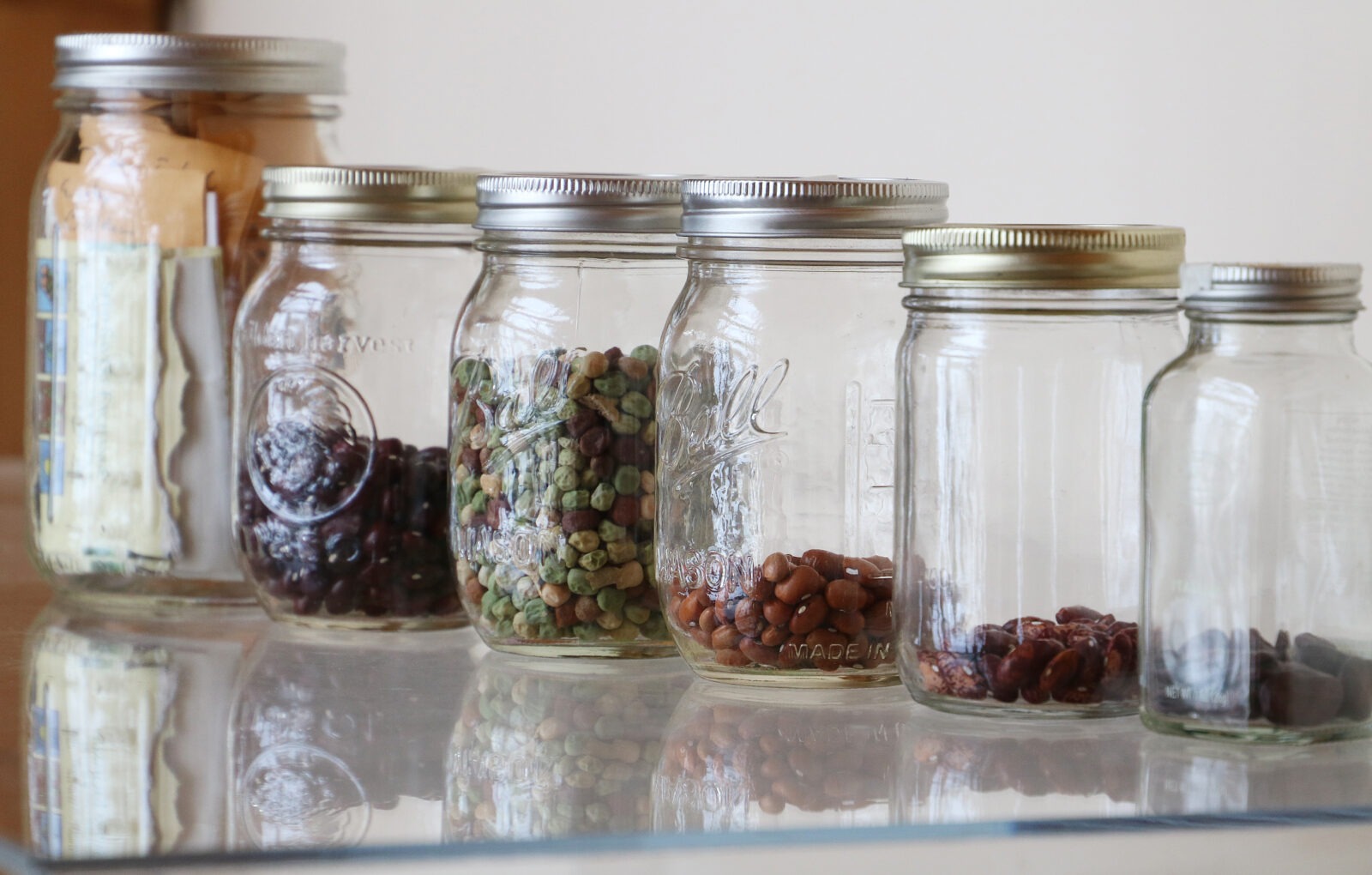 Seeds in glass mason jars and a mason jar holding papers