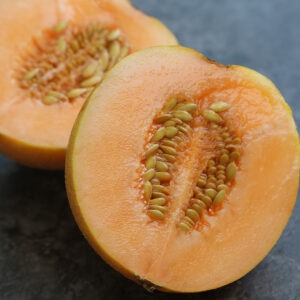 Two orange melon halves with many seeds in the middle