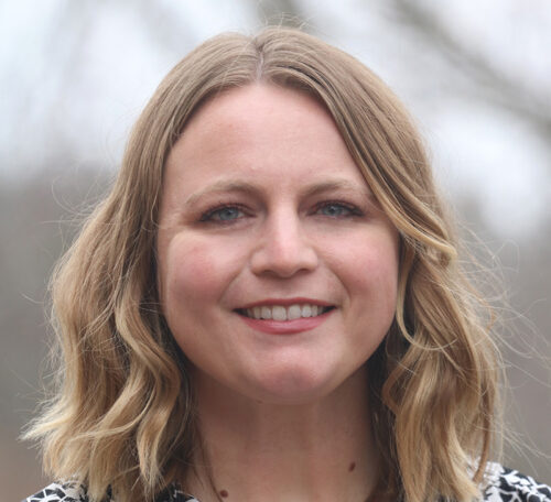 Woman with shoulder length hair smiles into camera.