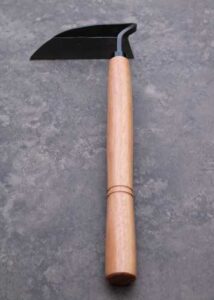 A forged steel hand hoe garden tool with a wooden handle