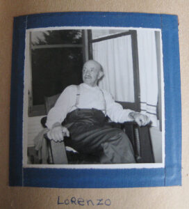 A black and white photo of man sitting in a living room chair, in a scrapbook with the written caption, "Lorenzo".