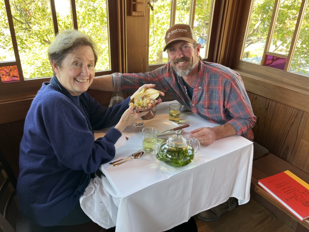 Two people sit at a table enjoying lunch.