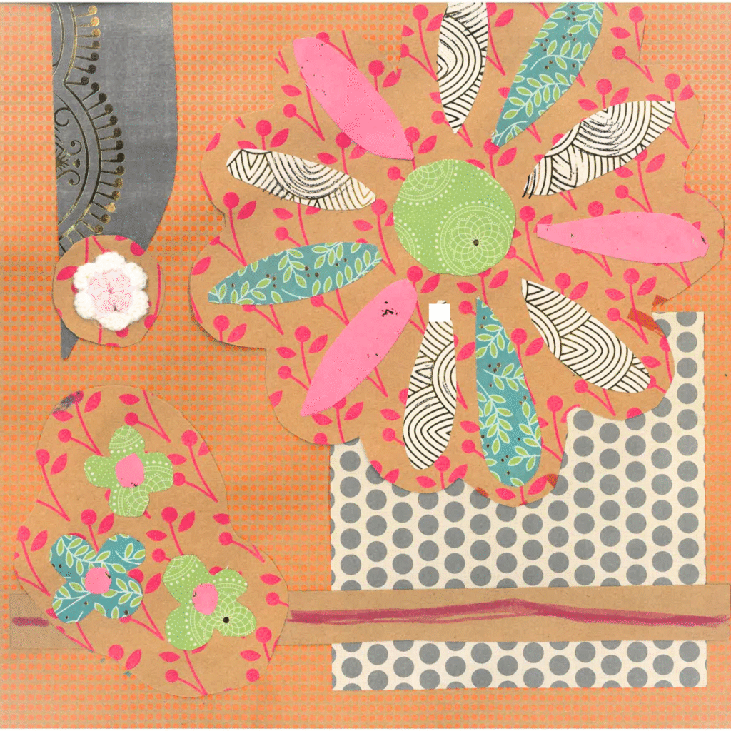 An orange scrapbook page with flowers and other shapes cut out of colorful paper