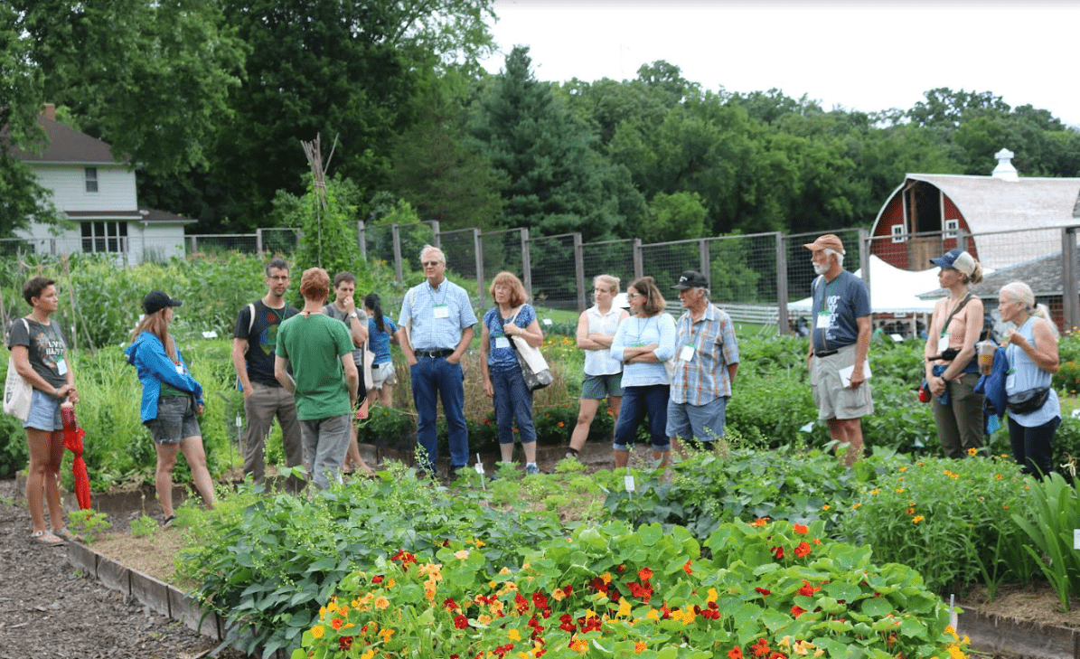 A group of people standing in a large garden