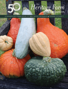 Text reads, "Seed Savers Exchange Heritage Farm Companion, Vol. 14, Issue 3." Photo of a variety of squash piled onto a wooden chair.